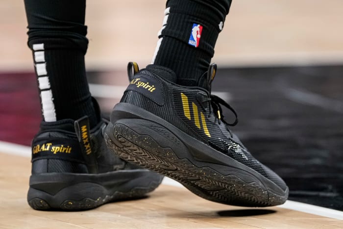 View of black and gold adidas shoes.